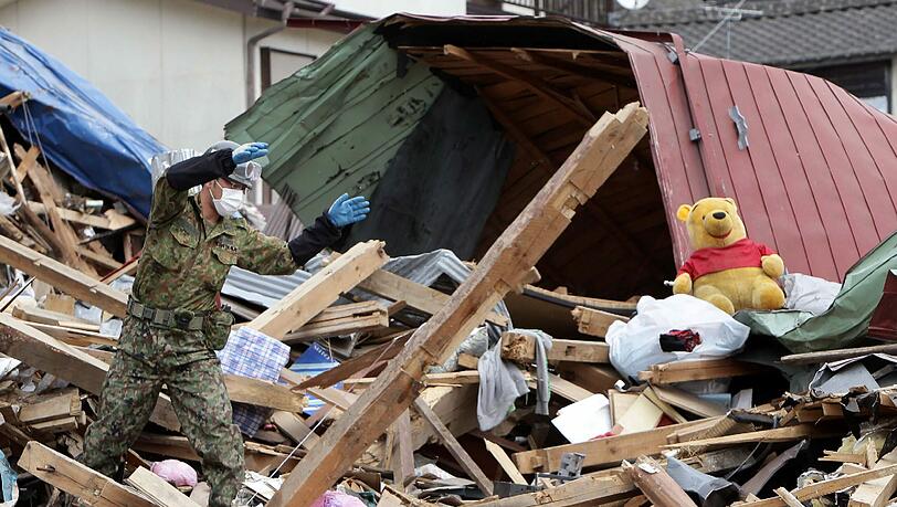 Japanische Soldaten suchen in den Trümmern in der Küstenstadt Otsuchi nach Leichen. Die genaue Zahl der Katastrophenopfer ist noch unklar. Japanische Soldaten suchen in den Trümmern in der Küstenstadt Otsuchi nach Leichen. Die genaue Zahl der Katastrophenopfer ist noch unklar.