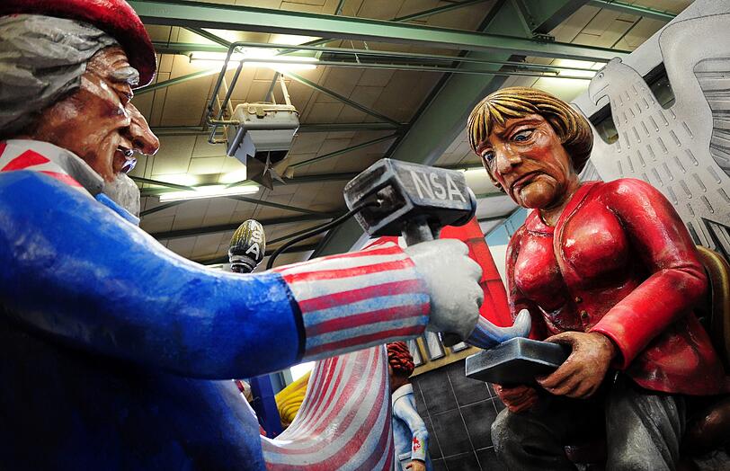 Der Mainzer Motivwagen "Der Spion, der aus dem Handy kam" zeigt einen amerikanischen "Uncle Sam", der wie ein Geist aus dem Mobiltelefon von Kanzlerin Merkel hervorkommt.