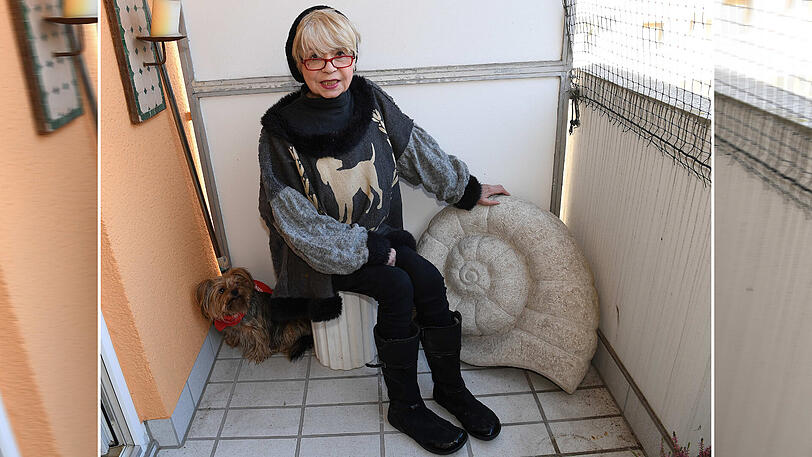 Ingrid Steeger mit Hund und steinerner Schnecke auf ihrem Balkon.