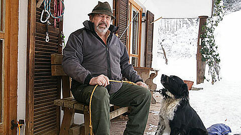 Kann dieser Mann Olympia stoppen? Theo Geyer, Bauer aus Garmisch, mit seinem mittelzärtlichen Hund Baschi vor seinem Haus. &bdquo;Mir wern behandelt, als wär ma gar net do.&ldquo;