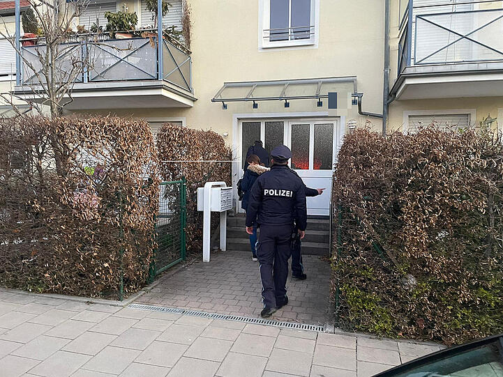 Vier Polizisten vor dem Mehrfamilienhaus in Moosach, in dem die verdächtige Frau lebt.