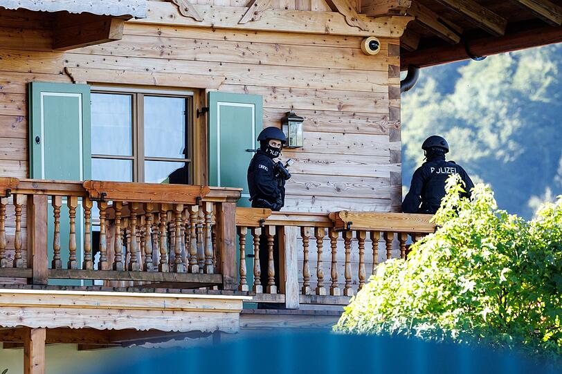 Maskierte Polizisten stehen auf dem Balkon von einem Haus Usmanows.