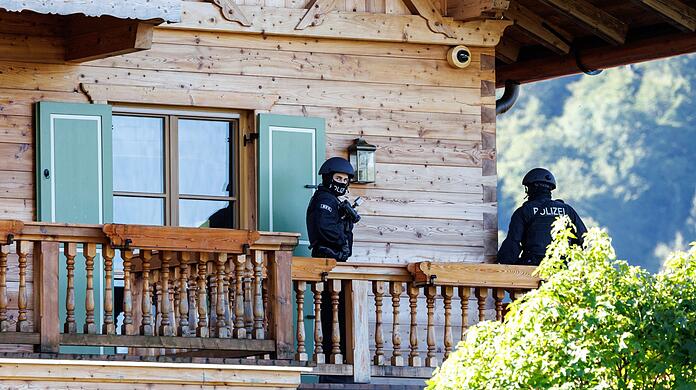Maskierte Polizisten stehen auf dem Balkon von einem Haus Usmanows.