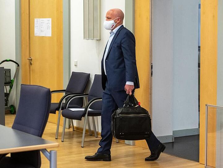Joachim Wolbergs, Regensburger Ex-Oberbürgermeister, geht mit Atemschutzmaske in den Verhandlungssaal im Landgericht. Foto: Armin Weigel/dpa/Archivbild