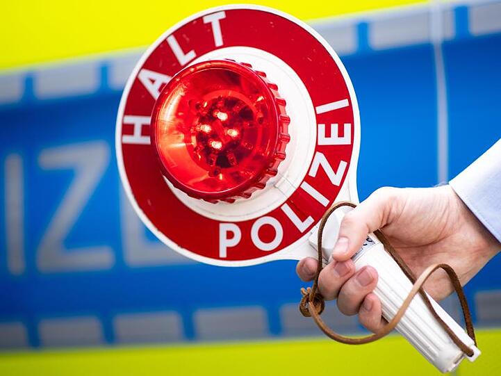Ein Polizist hält eine Polizeikelle mit der Aufschrift "Halt Polizei" in der Hand. Foto: Marius Becker/Archiv