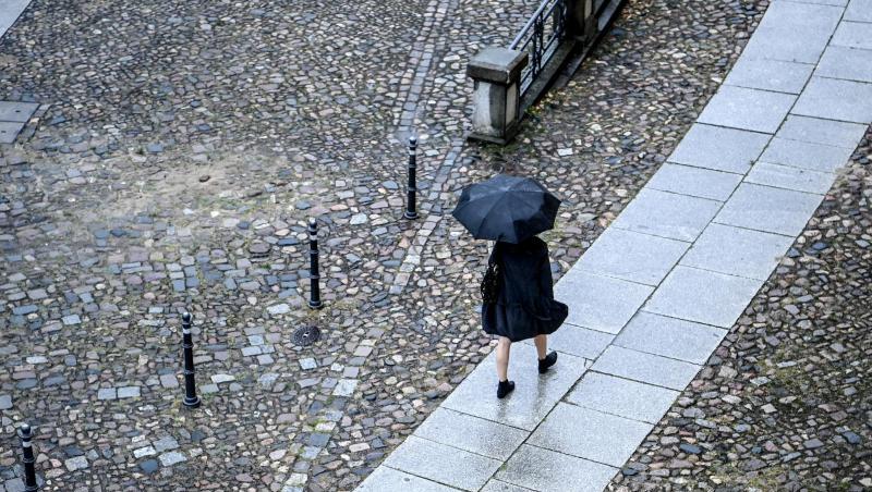 Eine Frau geht bei Regen eine Straße entlang. Foto: Britta Pedersen/dpa-Zentralbild/dpa/Symbolbild Eine Frau geht bei Regen eine Straße entlang. Foto: Britta Pedersen/dpa-Zentralbild/dpa/Symbolbild