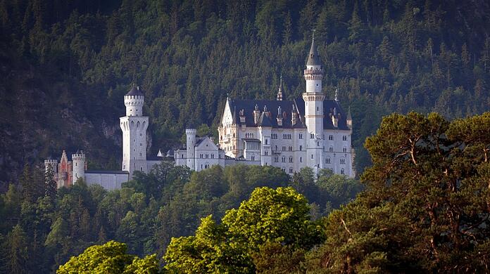 Das Schloss Neuschwanstein im Morgenlicht. Es ist von mittelalterlichen Burgen inspiriert.