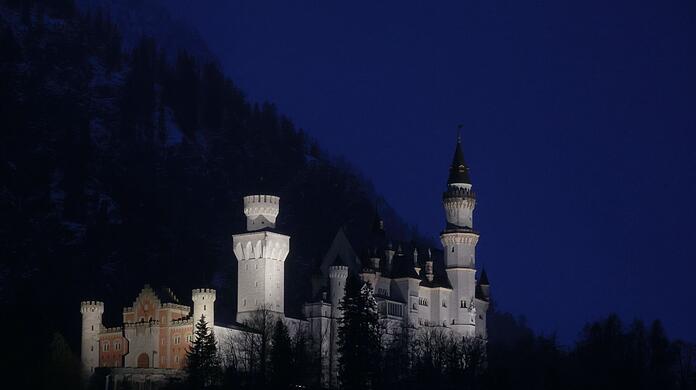 Von Scheinwerfern angestrahlt steht das Schloss Neuschwanstein im Königswinkel.