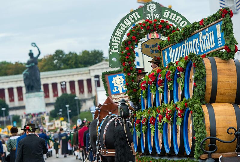 Trotz Nieselwetters rollten rund 40 Festwagen und Kutschen in dem sieben Kilometer langen Zug mit - und die Trachtler aus der ganzen Welt hatten dabei beste Laune.