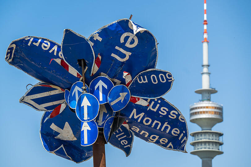 Eine riesige, künstliche Blume aus alten Verkehrschildern. Im Hintergrund: der Fernsehturm.