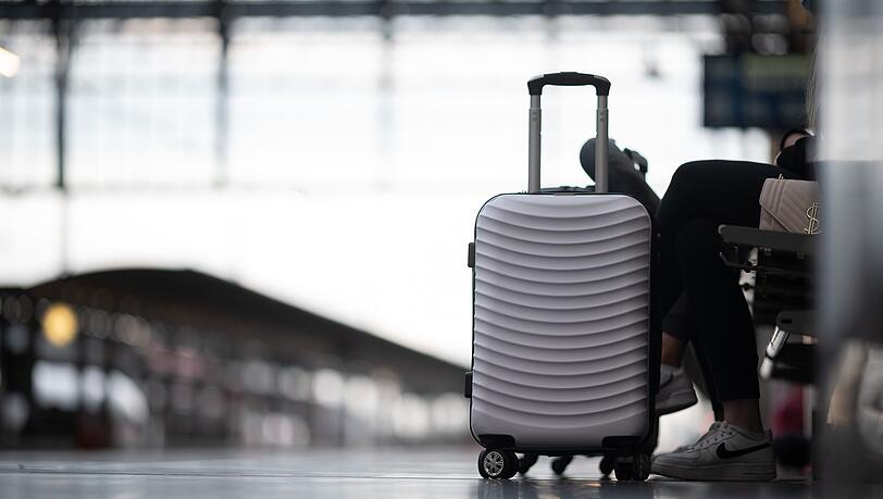 Passagiere warten am Bahnhof auf ihren Zug.