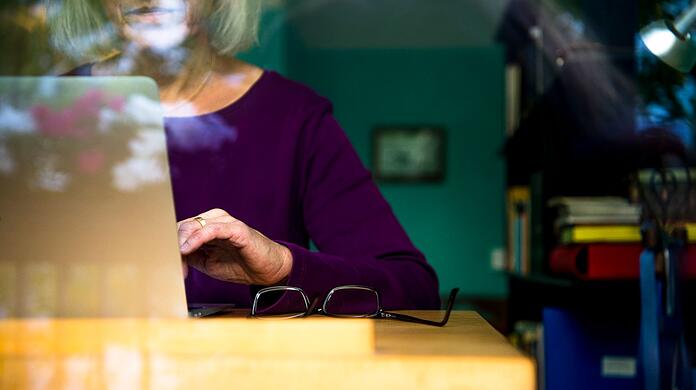Eine Frau arbeitet von Zuhause aus am Laptop.