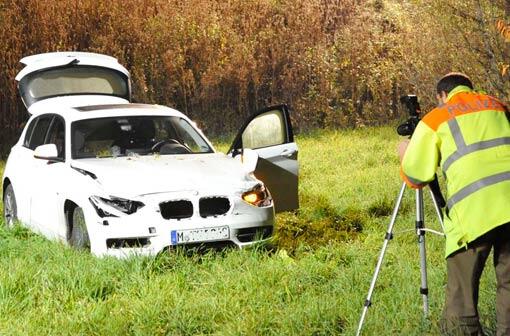 Das Ende einer Verfolgungsjagd: Ein Polizist bei der Unfallaufnahme, im Hintergrund der beschädigte BMW.