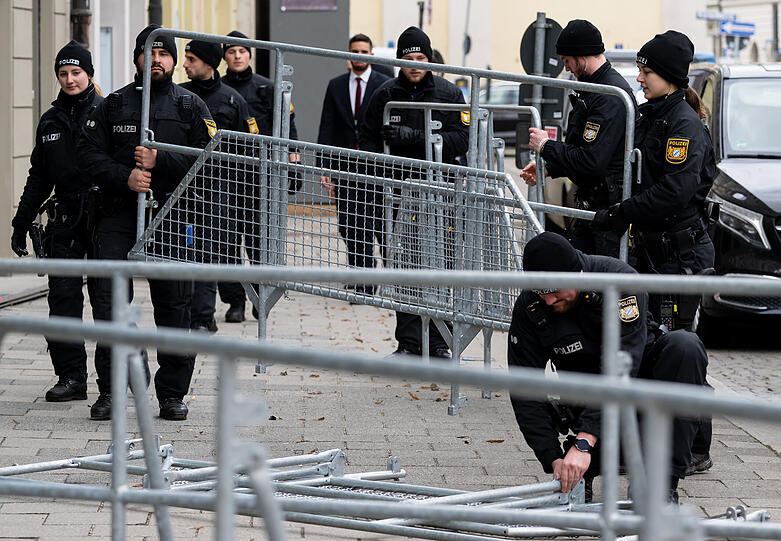 Polizisten bauen nach Abschluss der Sicherheitskonferenz Absperrgitter ab.