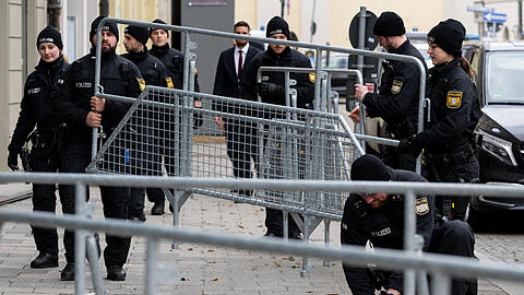 Polizisten bauen nach Abschluss der Sicherheitskonferenz Absperrgitter ab.