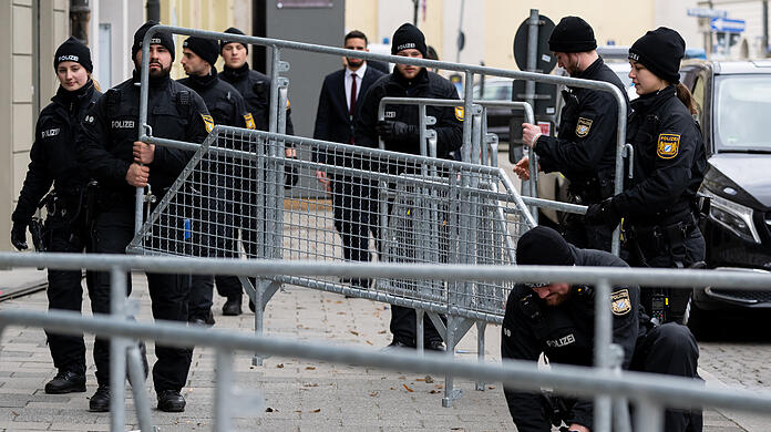 Polizisten bauen nach Abschluss der Sicherheitskonferenz Absperrgitter ab.