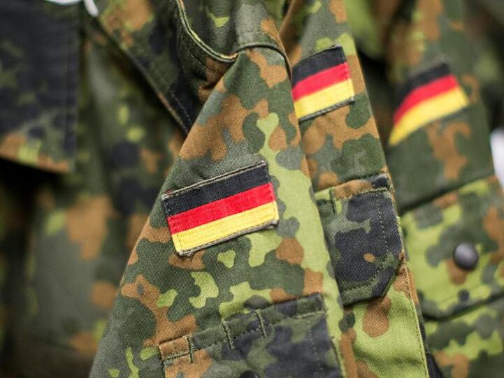 Jacken der Bundeswehr mit angenähter Deutschlandflagge hängen an einer Garderobe. Foto: picture alliance / Marcel Kusch/dpa/Symbolbild