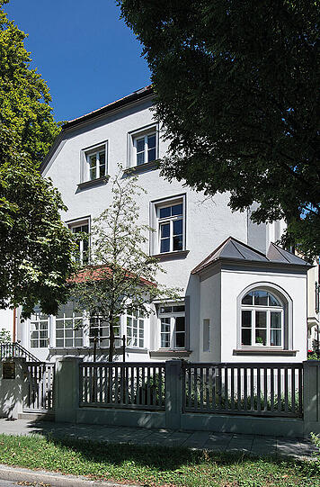 Kratzerstraße 18: Das denkmalgeschützte, historisierende Wohn- und Geschäftshaus wurde 1895 vom Baugeschäft Heilmann & Littmann als Eckhaus der Reihenhausgruppe in der Tizianstraße erbaut.