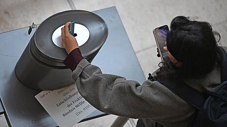 Bei einer namentlichen Abstimmung werfen die Abgeordneten personalisierte blaue (Ja), rote (Nein) oder wei&szlig;e (Enthaltung) Stimmkarten ein. (Archivbild)