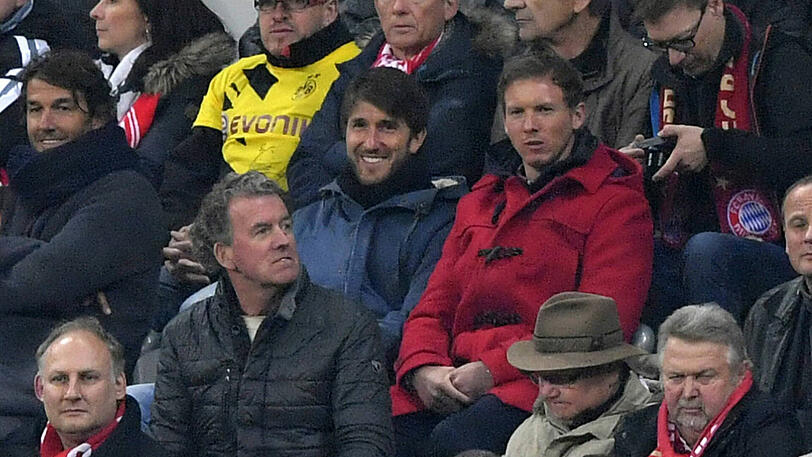 Julian Nagelsmann in seinem roten Mantel beim Stadionbesuch in München.