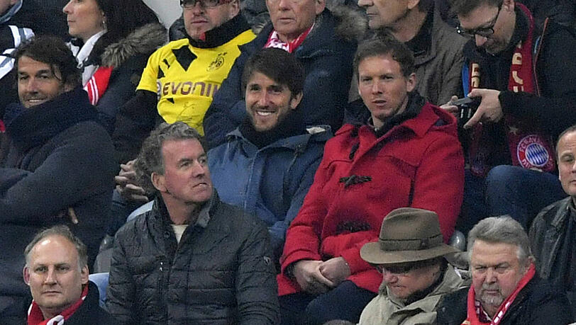 Julian Nagelsmann in seinem roten Mantel beim Stadionbesuch in München.