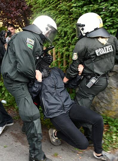 Polizisten nehmen einen Demonstranten in Gewahrsam.