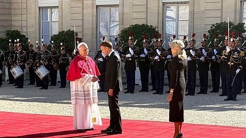 Frankreichs Pr&auml;sident Emmanuel Macron und seine Ehefrau Brigitte sch&uuml;tteln H&auml;nde mit dem Papst im Hof des &Eacute;lys&eacute;e-Palastes.