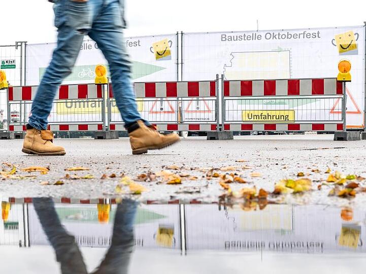 Ein Mann läuft an der Baustelle des Oktoberfestes vorbei. Foto: Sina Schuldt