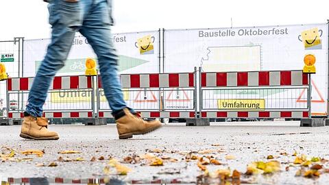 Ein Mann läuft an der Baustelle des Oktoberfestes vorbei. Foto: Sina Schuldt