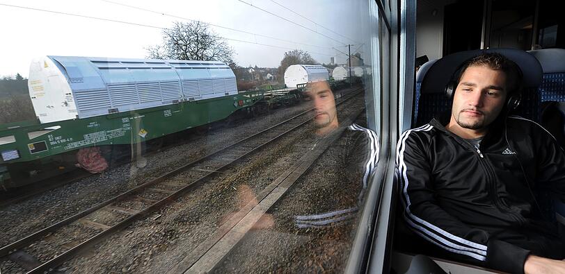 Ein Bahnreisender spiegelt in der Scheibe seines Bahnabteils, waehrend der Zug an dem im Bahnhof der franzoesischen Kleinstadt Remilly stehenden Castor-Zug vorbeifaehrt.