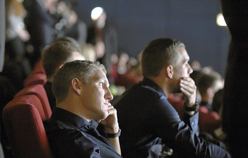 Bastian Schweinsteiger und Lukas Podolski schauen sich den Film "Die Mannschaft" an.