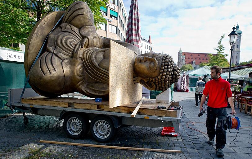 Ende einer Kunstaktion: Der liegende Buddha vom Viktualienmarkt wird abgebaut und auf einem Tieflader festgezurrt.