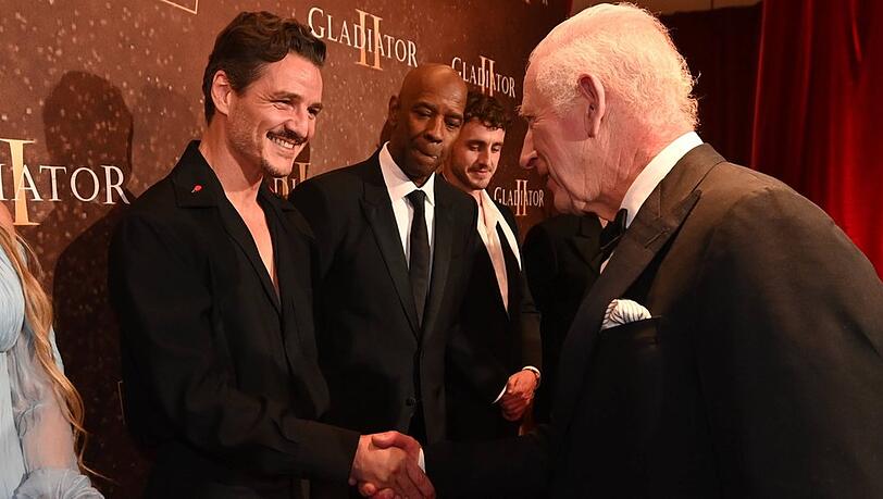Pedro Pascal (li.) beim Händeschütteln mit König Charles (re.).