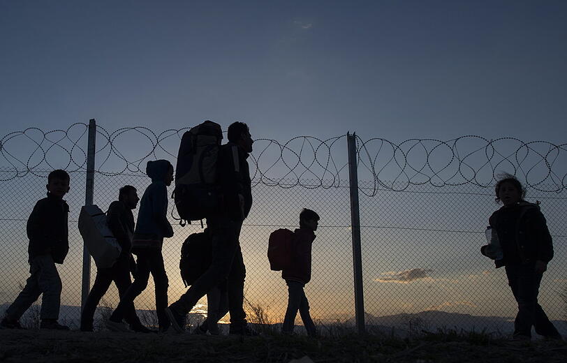 Flüchtlinge sind im Jahr 2016 auf dem Weg zu einem Transit-Camp, nachdem sie die Grenze zwischen Griechenland und Mazedonien überschritten haben.