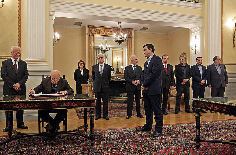 Alexis Tsipras bei seiner Vereidigung in Athen. Präsident Karolos Papoulias (m. sitzend) unterschreibt die Protokolle.