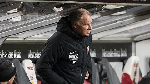 Augsburgs Sportdirektor Stefan Reuter steht vor der Trainerbank.