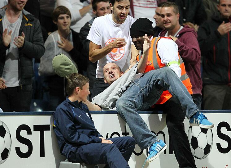 Voller Einsatz: Hier versucht ein Fan - vergeblich - das Spielfeld zu entern.
