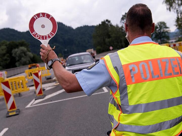Polizisten kontrollieren an einer mobilen Kontrollstelle in Bayern Fahrzeuge, die aus Österreich kommen. Foto: Sven Hoppe/Archiv