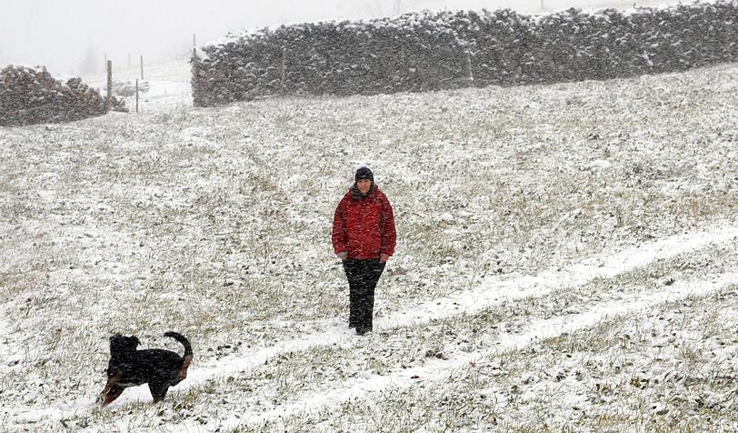 Eine Spaziergängerin und ihr Hund auf dem Schauinsland im Schwarzwald. Auch in Baden-Württemberg hat es heute geschneit.
