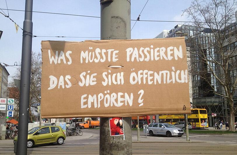 Eins von mehreren Plakaten - hier an der Ecke Arnulfstraße/Bahnhogsplatz. Das Papageien-Bild klebt zufällig auf dem Masten.