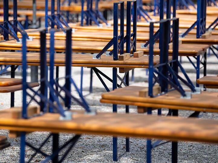 Menschenleer zeigt sich ein Biergarten mit gestapelten Bänken und Tischen im Westpark in München.