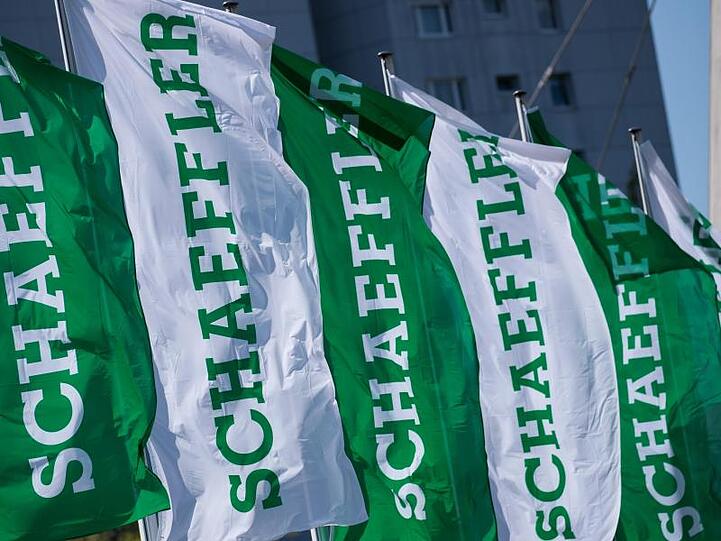 Blick auf wehende Fahnen mit dem Schriftzug der Schaeffler AG. Foto: Daniel Karmann/dpa/Symbolbild