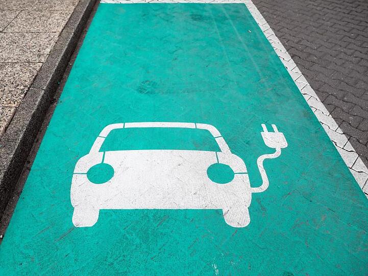 Eine Markierung zeigt einen Parkplatz mit Ladesäule für Elektrofahrzeuge an.