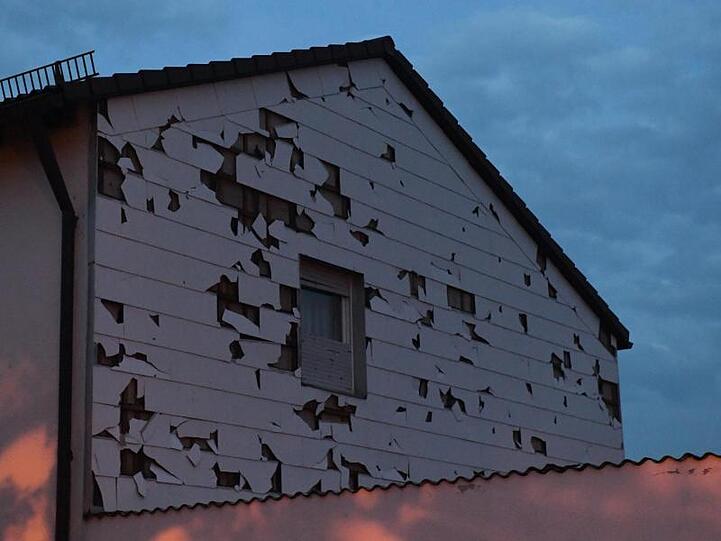 Eine durch Hagel zerstörte Hausverkleidung in einem bayrischen Dorf.