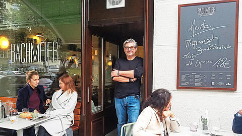 Sichtlich glücklich über sein neues Restaurant: Spitzenkoch Hans Jörg Bachmeier (Mitte) vor dem holzvertäfelten Eingang, der vom Vorgänger-Lokal erhalten blieb.