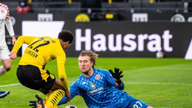 Der Mainzer Torwart Robin Zentner (r) sptitzelt Dortmunds Jude Bellingham den Ball vom Fuß.