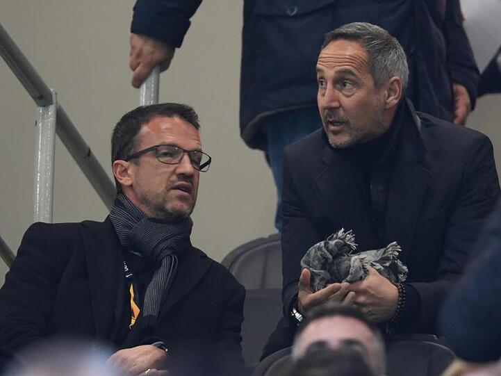 Frankfurts gesperrter Trainer Adi Hütter (r) unterhält sich auf der Tribüne im Guiseppe-Meazza-Stadion mit Sportvorstand Fredi Bobic.
