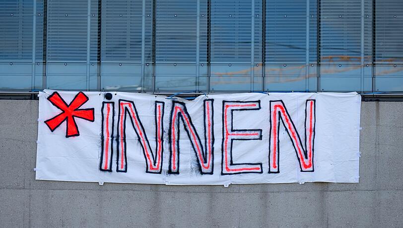 Ein Plakat mit der Aufschrift "*Innen" ist an einer Hochschule zu sehen.