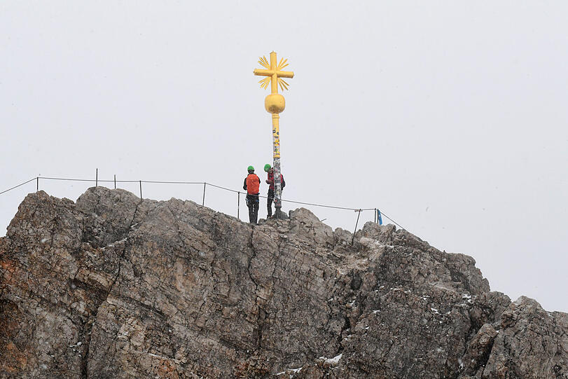 Das Gipfelkreuz des Zugspitzgipfels bei Wolken.