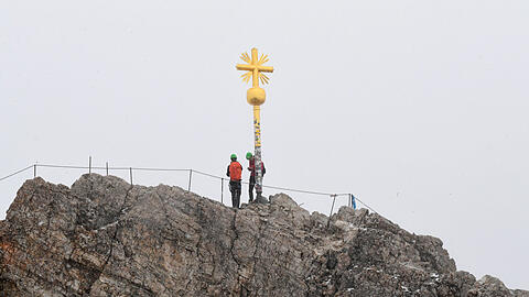 Das Gipfelkreuz des Zugspitzgipfels bei Wolken.